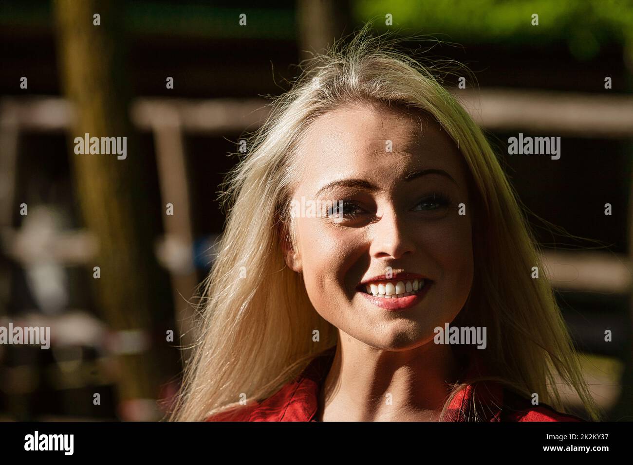 Ritratto ad alto contrasto di una giovane donna bionda sorridente Foto Stock