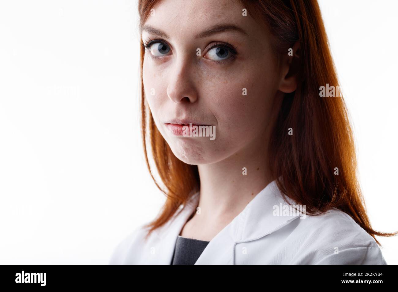 Giovane donna seria che guarda la macchina fotografica con gli occhi grandi Foto Stock