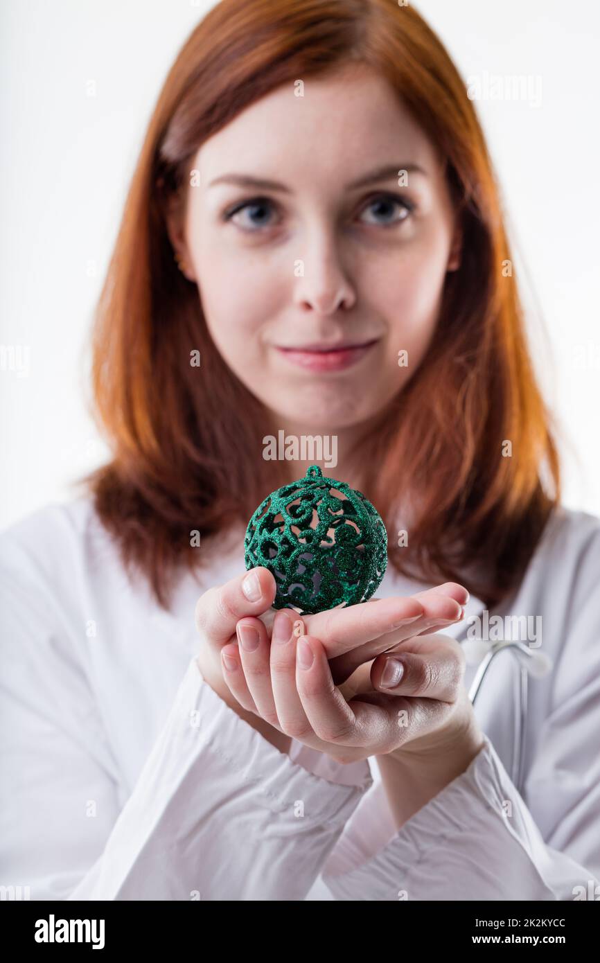 medico in possesso di una palla di natale Foto Stock