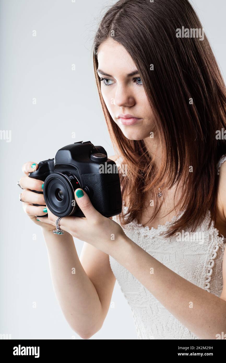 bella ragazza che tiene una fotocamera reflex Foto Stock