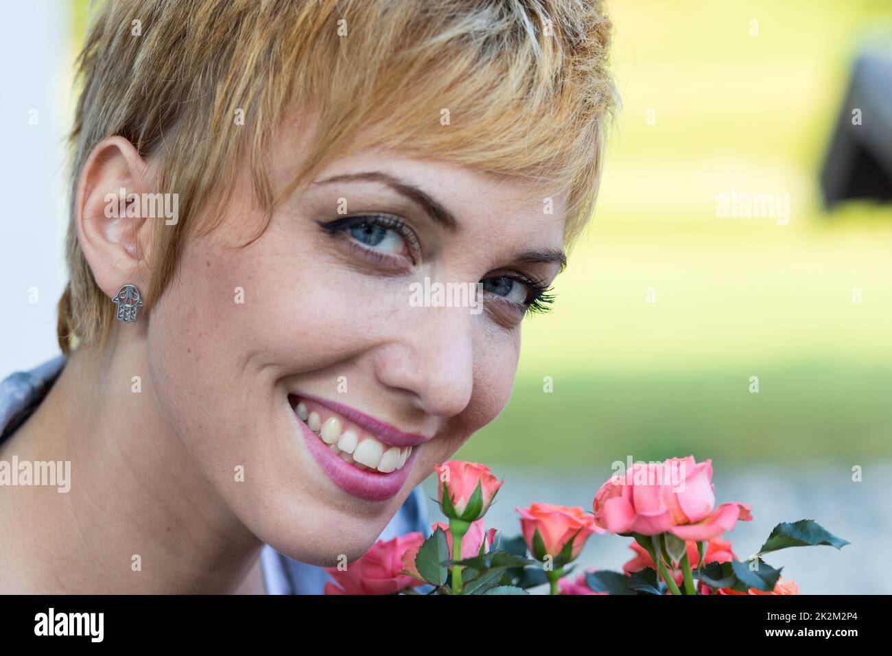 vera donna che odora fiori all'aperto Foto Stock