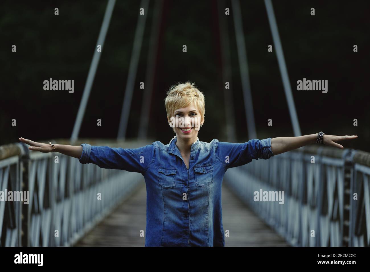 ritratto di giovane donna su ponte e braccia distese Foto Stock