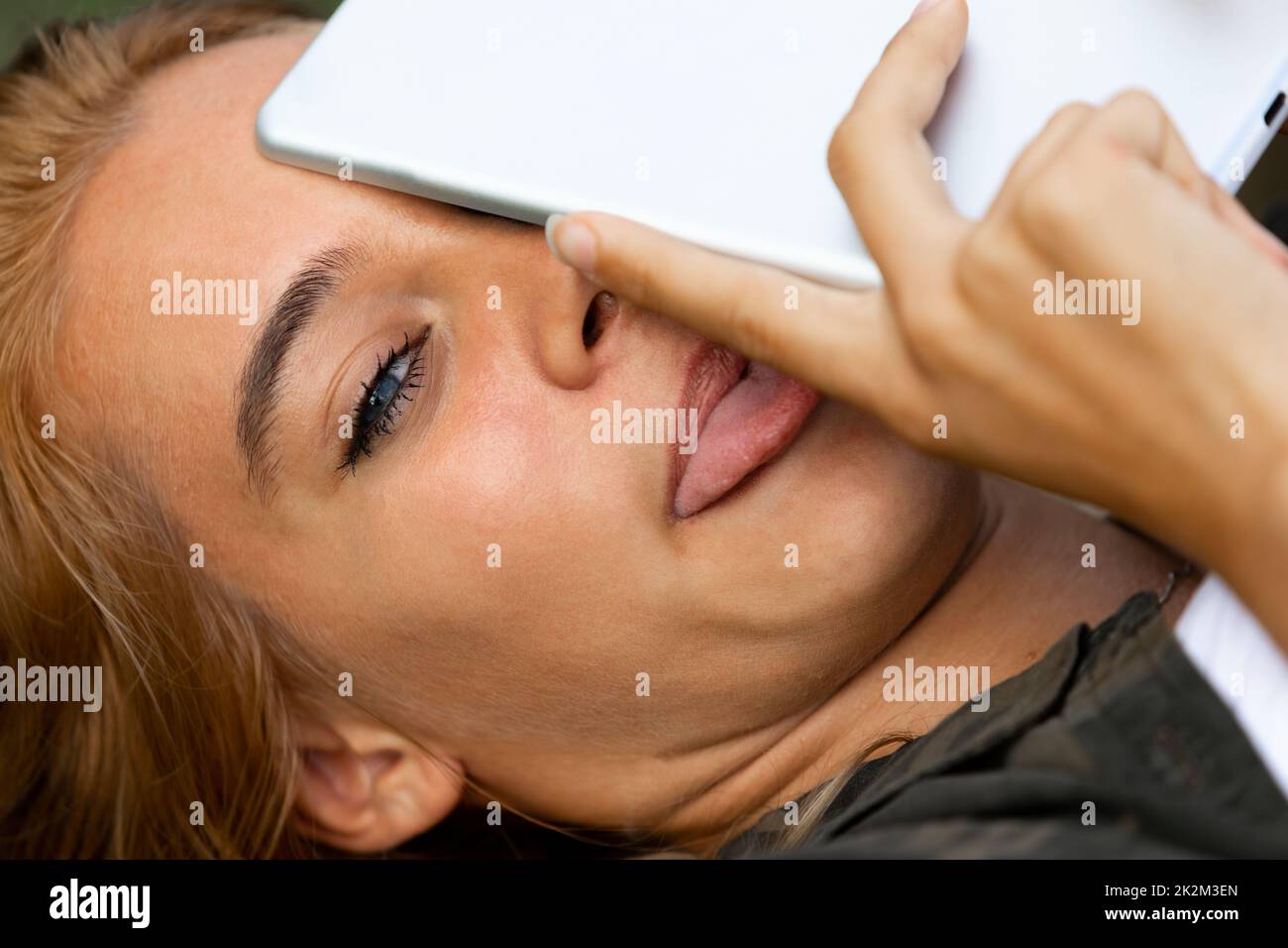 Giovane donna che copre un occhio con un tablet-pc Foto Stock