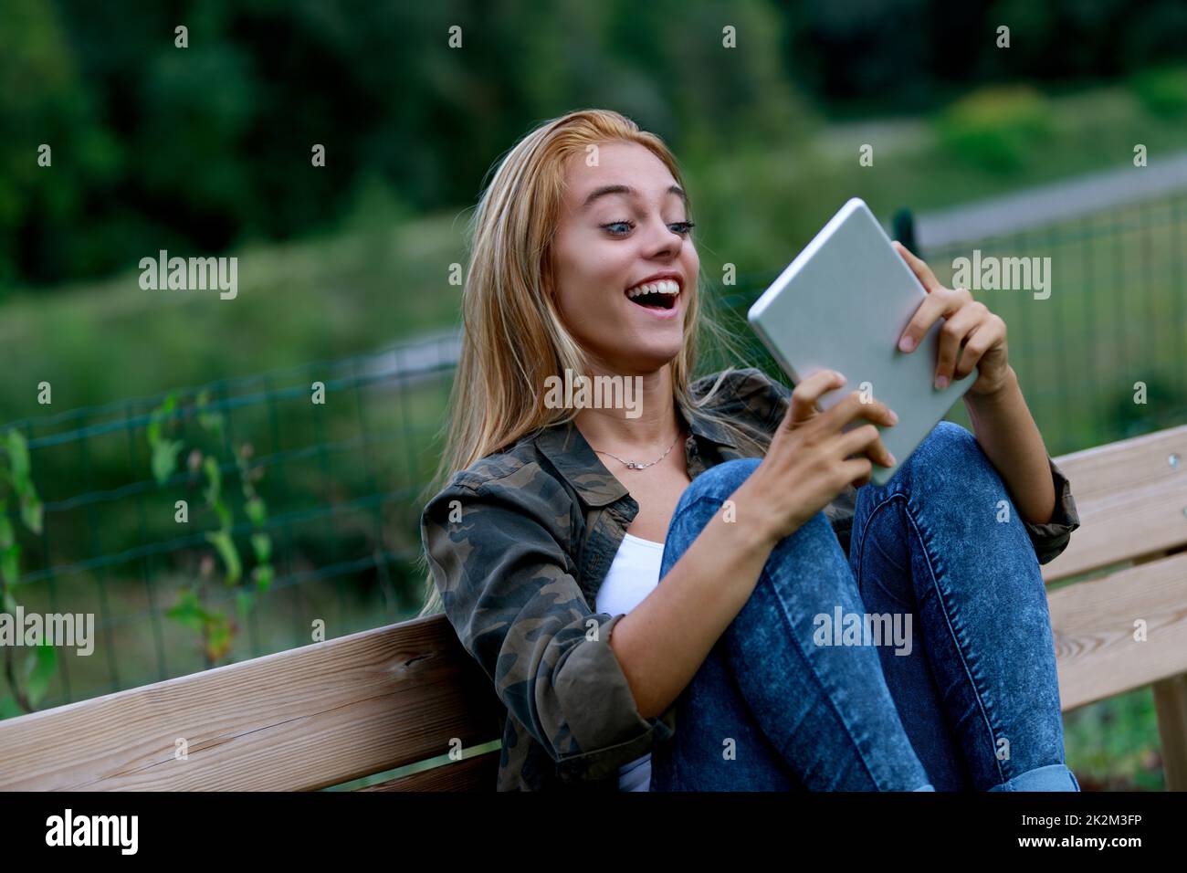 Gleeful sorpresa giovane donna fissando il suo tablet Foto Stock