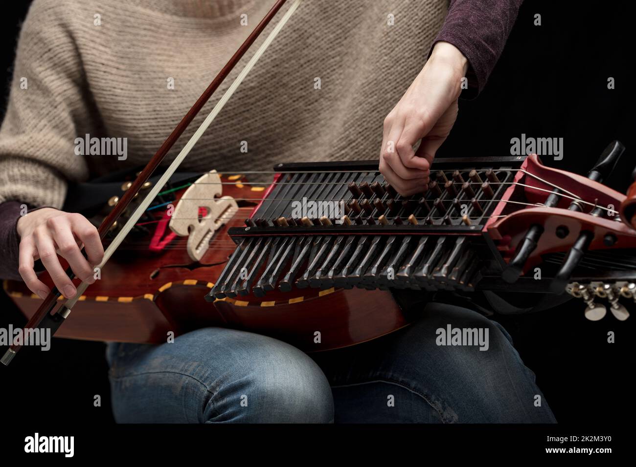 Musicista femminile che sintonizza la sua moderna nyckelharpa Foto Stock