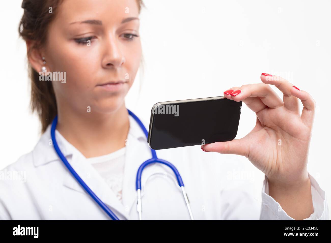 Medico che legge un messaggio di testo su un cellulare Foto Stock