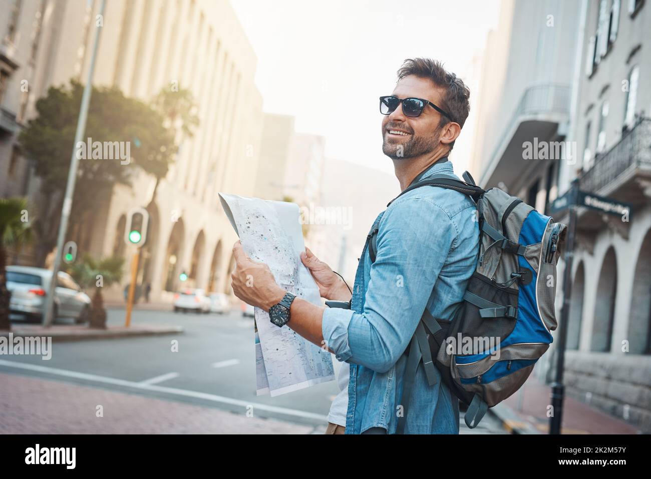 Scopri le meraviglie naturali, culturali e artificiali del mondo. Scatto di un giovane che guarda una mappa mentre si visita una città straniera. Foto Stock