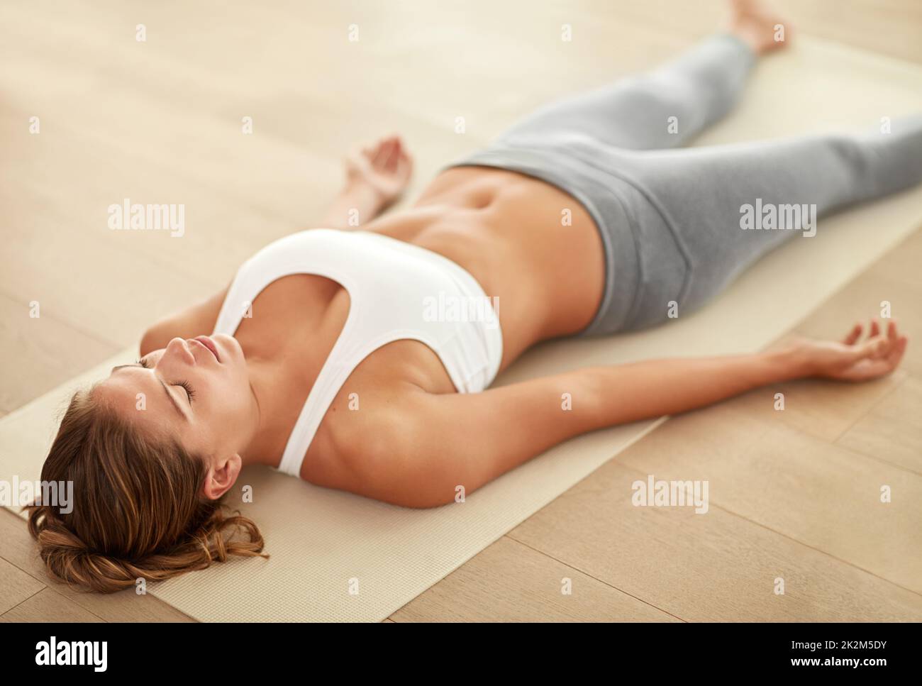 Inspirate... respirate Scatto di una giovane donna sportiva che fa un esercizio di rilassamento. Foto Stock