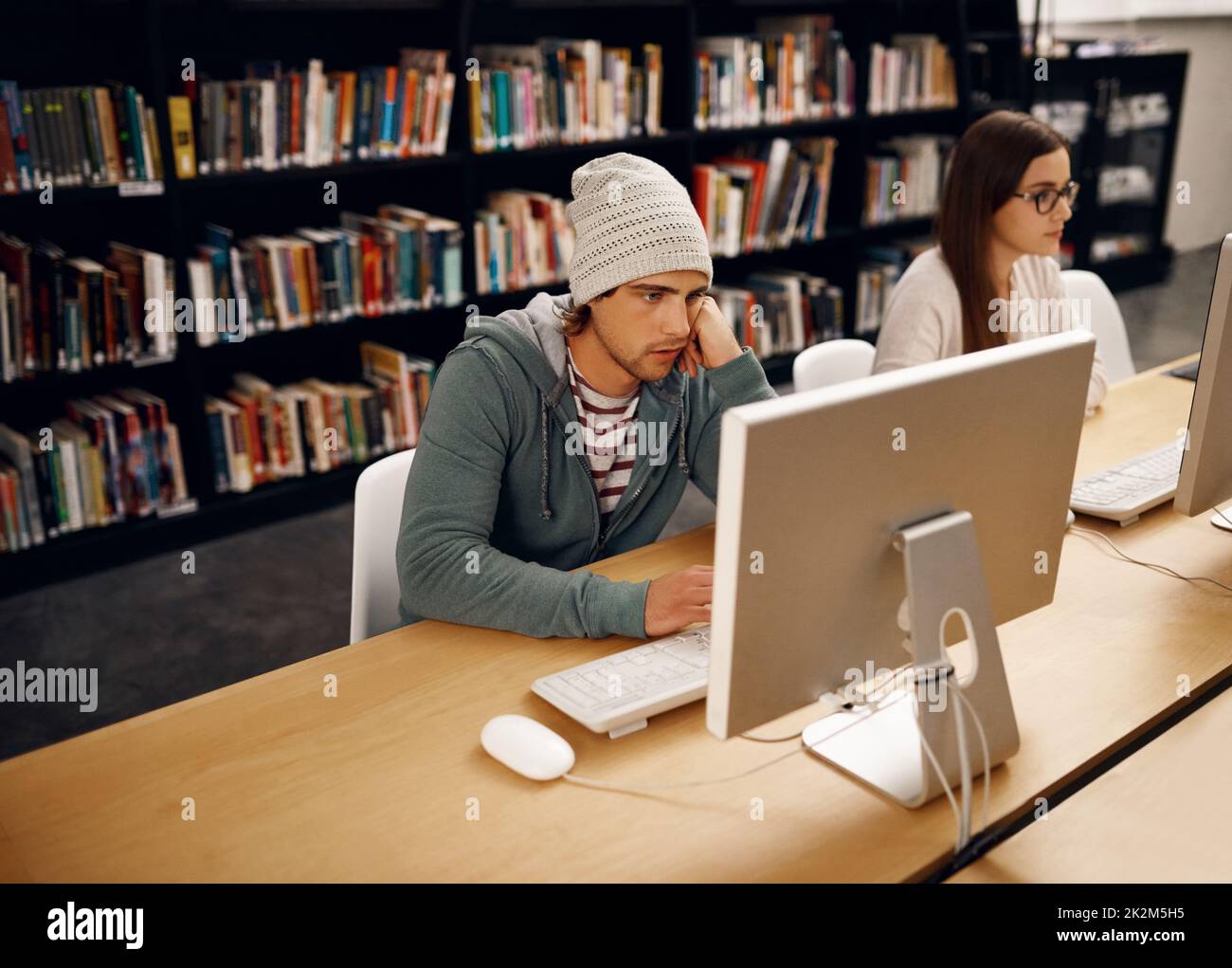 Il suo tempo di esame. Scatto ad alto angolo di due giovani studenti universitari che studiano in biblioteca. Foto Stock