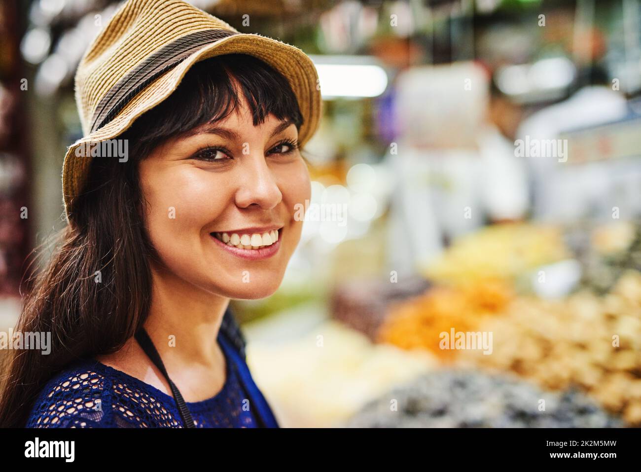 Così tanto da vedere, tanto da scegliere da. Ritratto di una giovane donna allegra in piedi nel mezzo di un mercato occupato fuori durante il giorno. Foto Stock