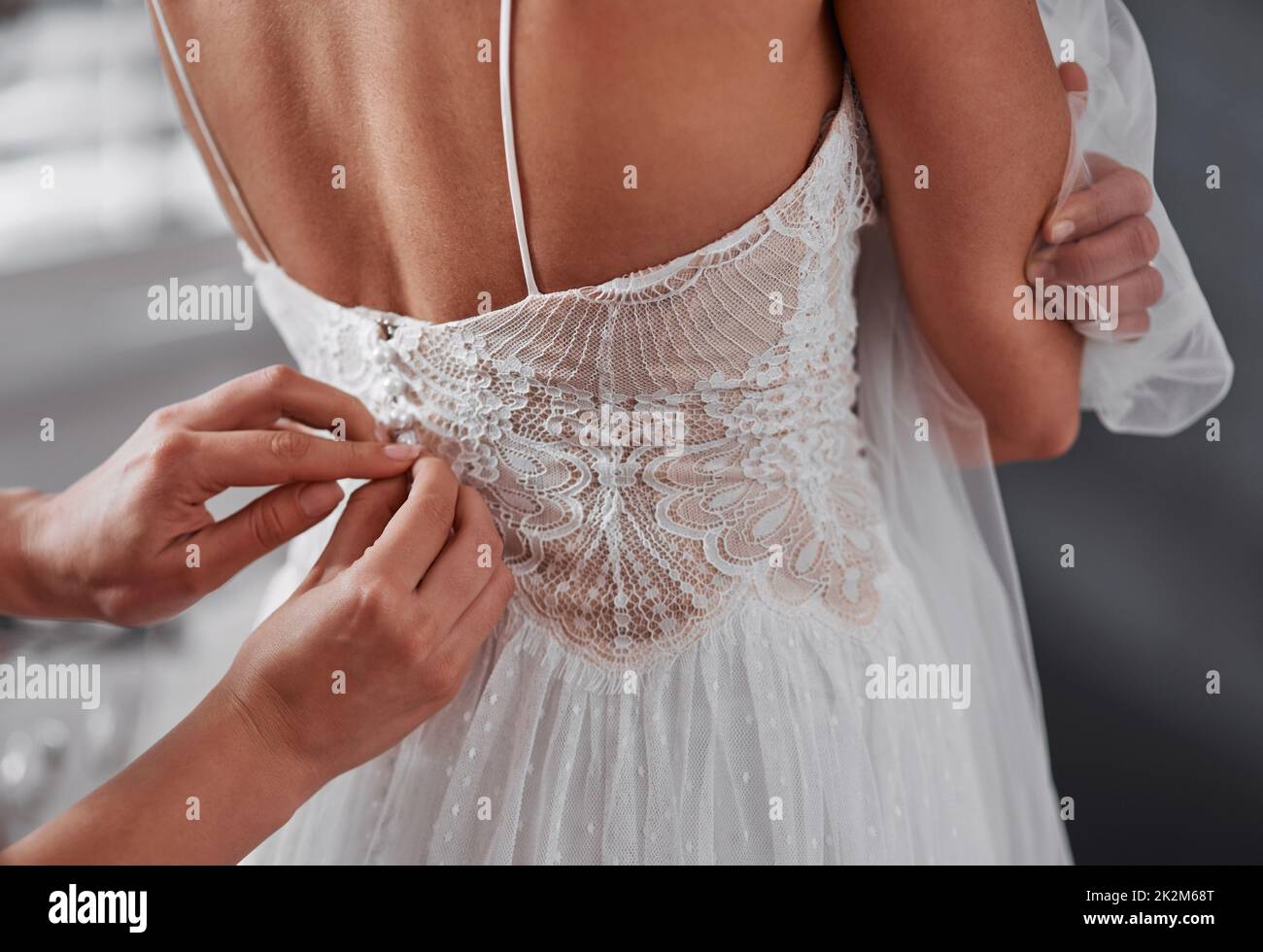 Aiutarla Preparati. Scatto corto di una bridesmaid irriconoscibile che aiuta la sposa a prepararsi per la sua cerimonia nuziale. Foto Stock