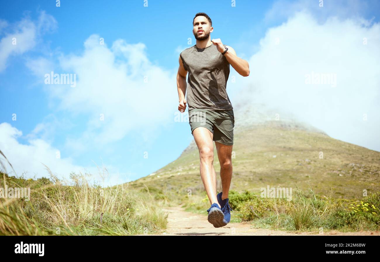 Costruisca un mindset forte e il corpo seguirà. Inquadratura ad angolo basso di un giovane sportivo che corre all'aperto. Foto Stock