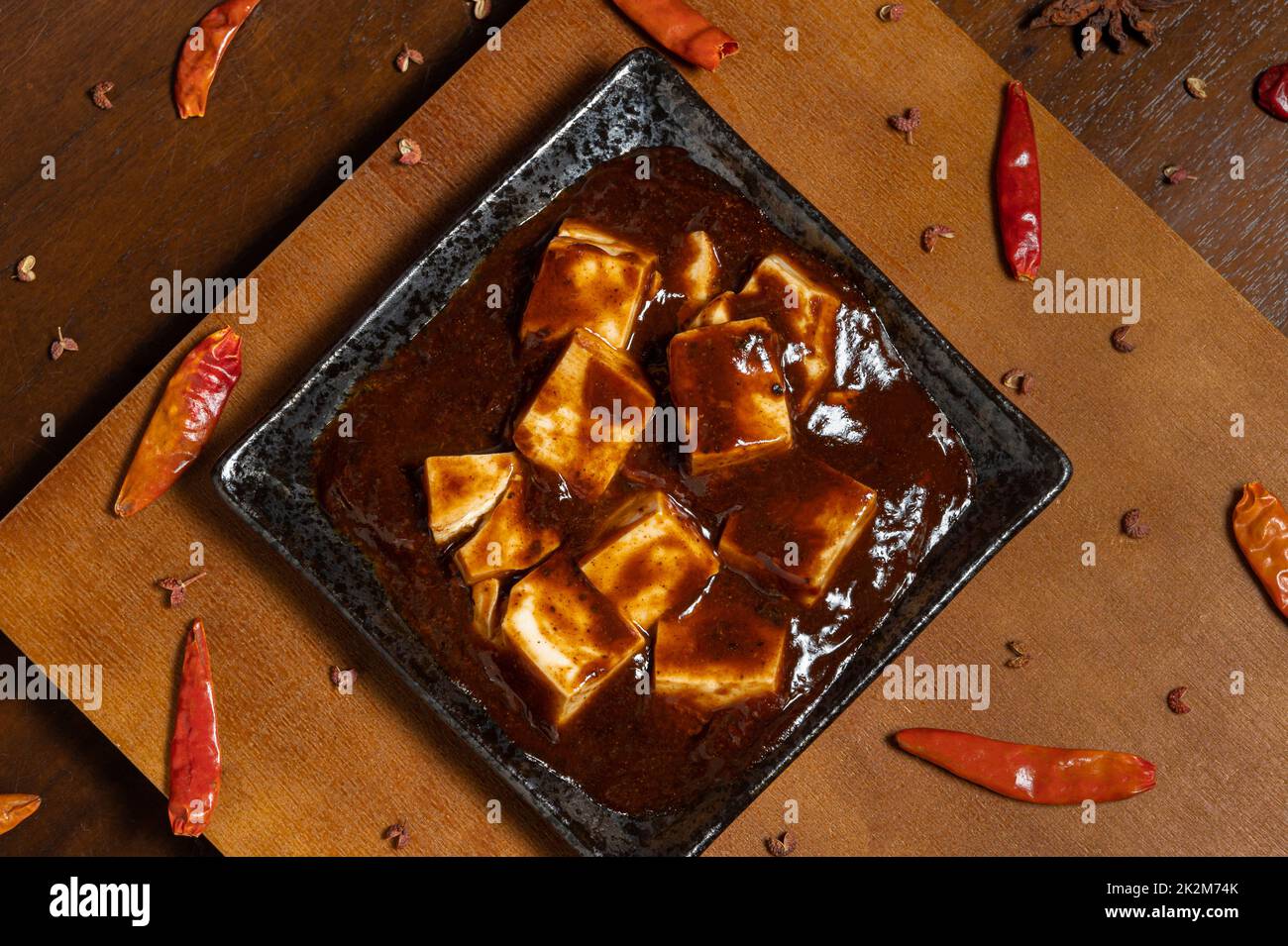 Cibo tradizionale cinese, Mapo tofu (tofu piccante caldo) con riso, decorazioni antiche e spezie (pepe, peperoncino e anice stellato). Foto Stock