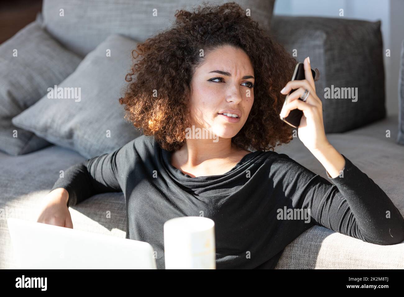 Donna che lotta per leggere lo schermo sul suo cellulare Foto Stock