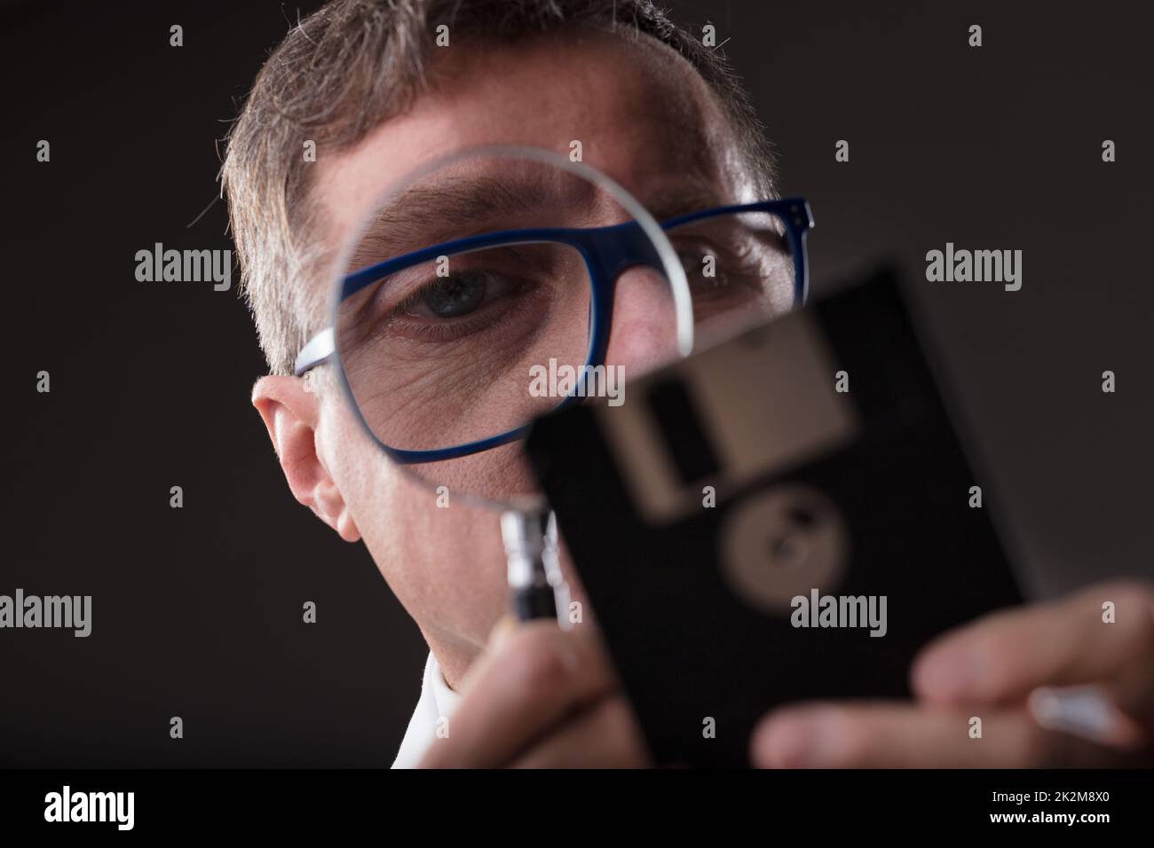 uomo che controlla i dati con una lente di ingrandimento (concetto di analisi dei dati) Foto Stock