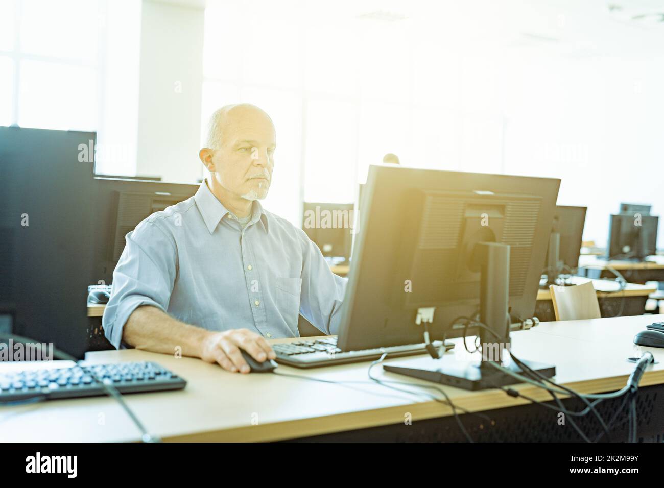 Immagine chiave alta di un uomo d'affari al lavoro con luce solare Foto Stock