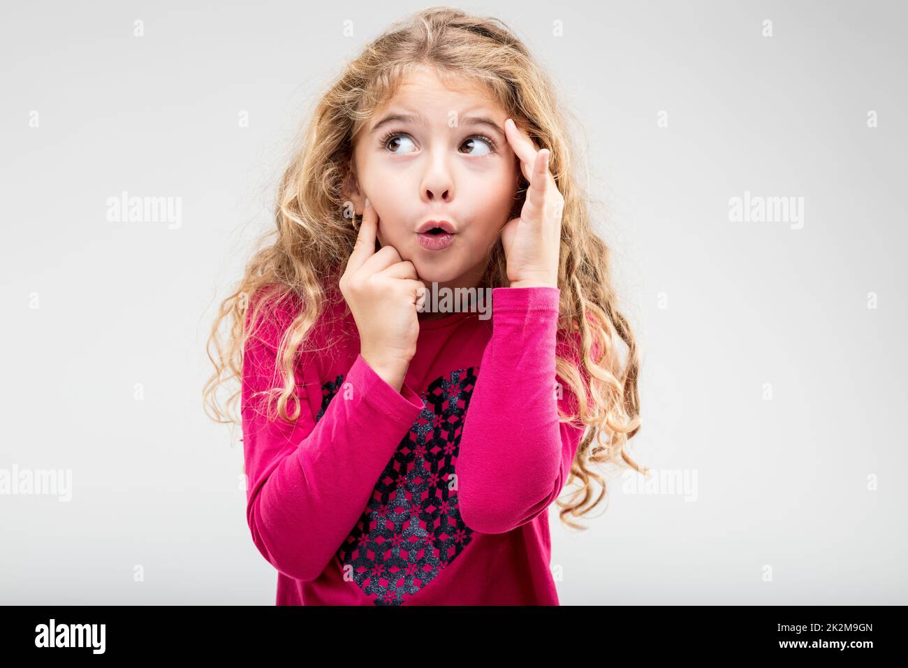 Divertente bambina allegra con un'espressione stuzzicante Foto Stock