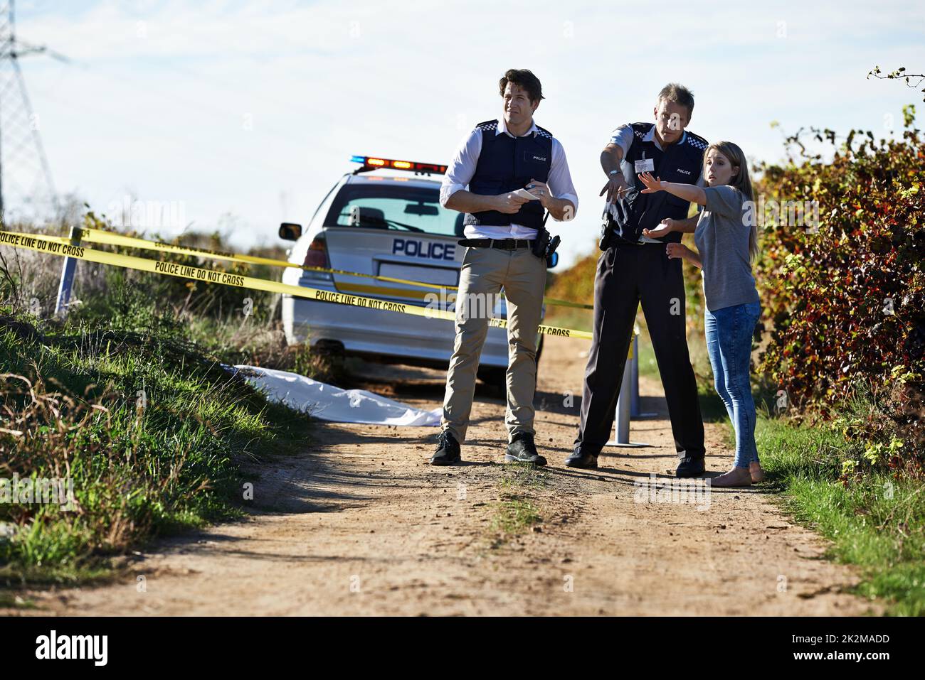 Ottenere la sua dichiarazione. Sparato di una donna che mostra ufficiali di polizia dove ha trovato il corpo ad un crimycene. Foto Stock