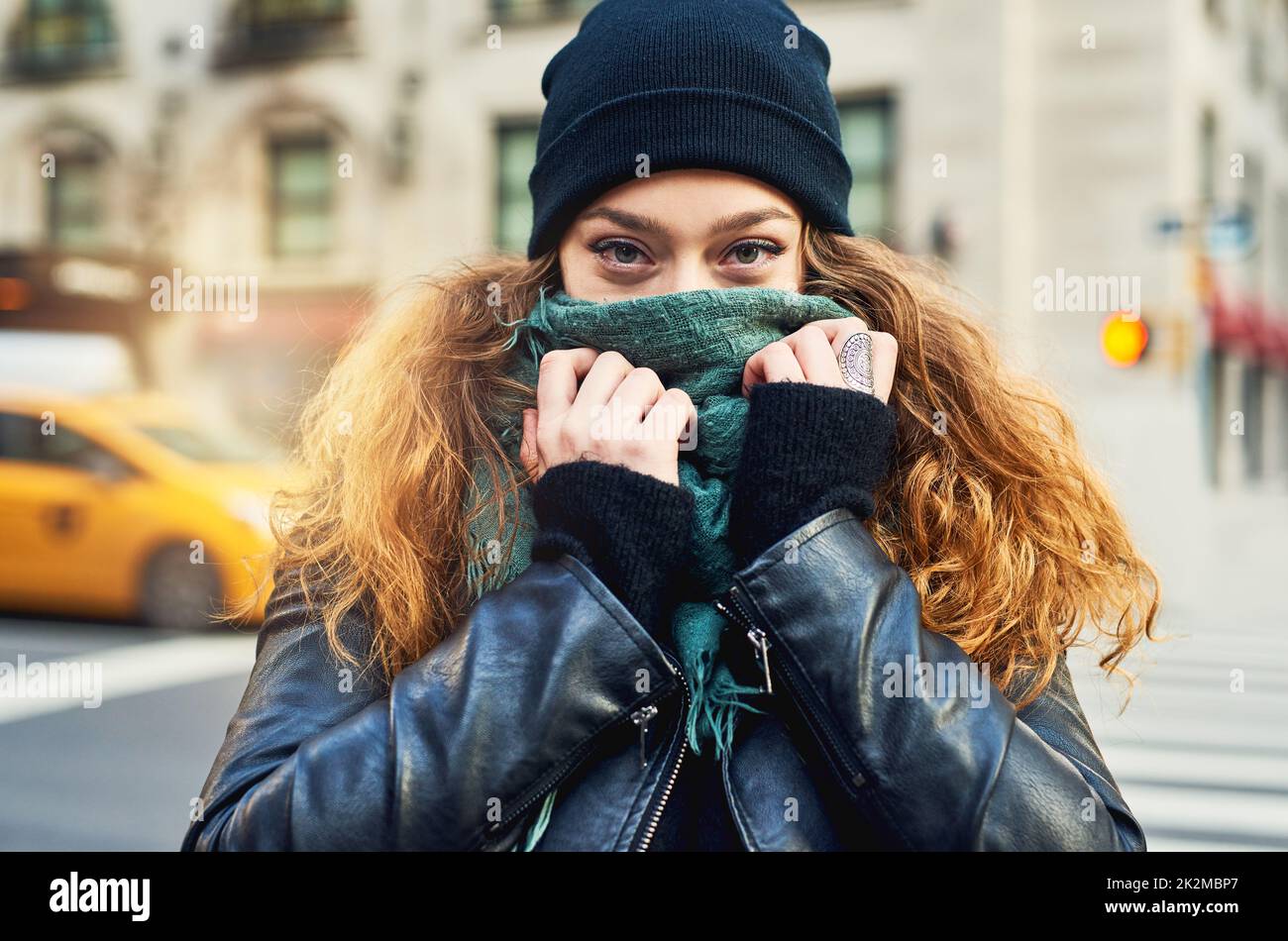 Questa è la mia città. Scatto di una donna che copre la bocca con la sua sciarpa mentre fuori in città. Foto Stock