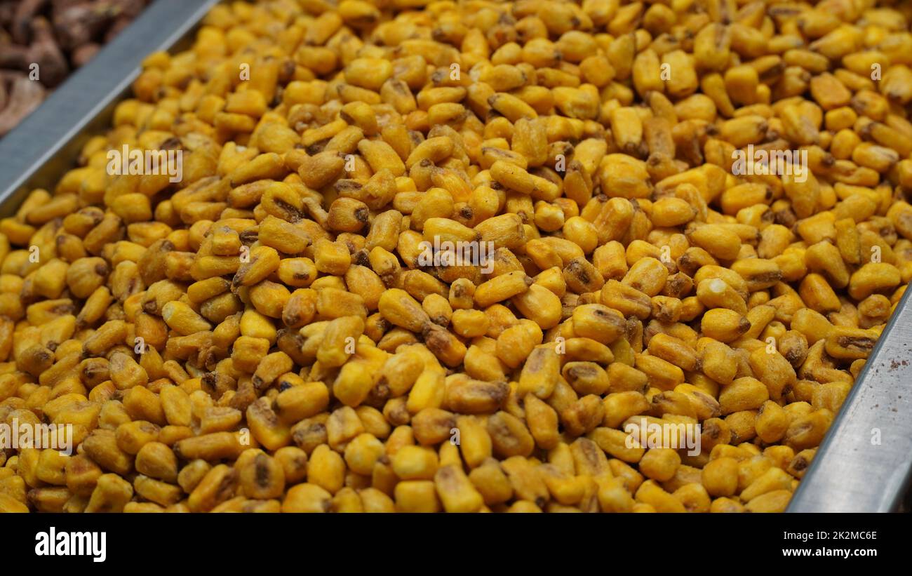 Noci di granoturco salate arrosto in vendita sul mercato locale. Snack alla birra, mais secco con spezie Foto Stock