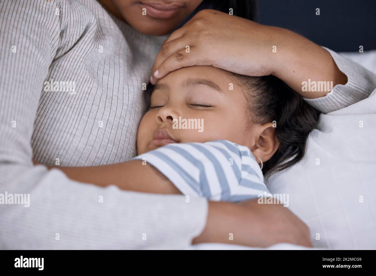 Non riesco mai a avvicinarmi abbastanza alla mamma. Shot di una bambina adorabile che dorme accanto alla madre a casa. Foto Stock