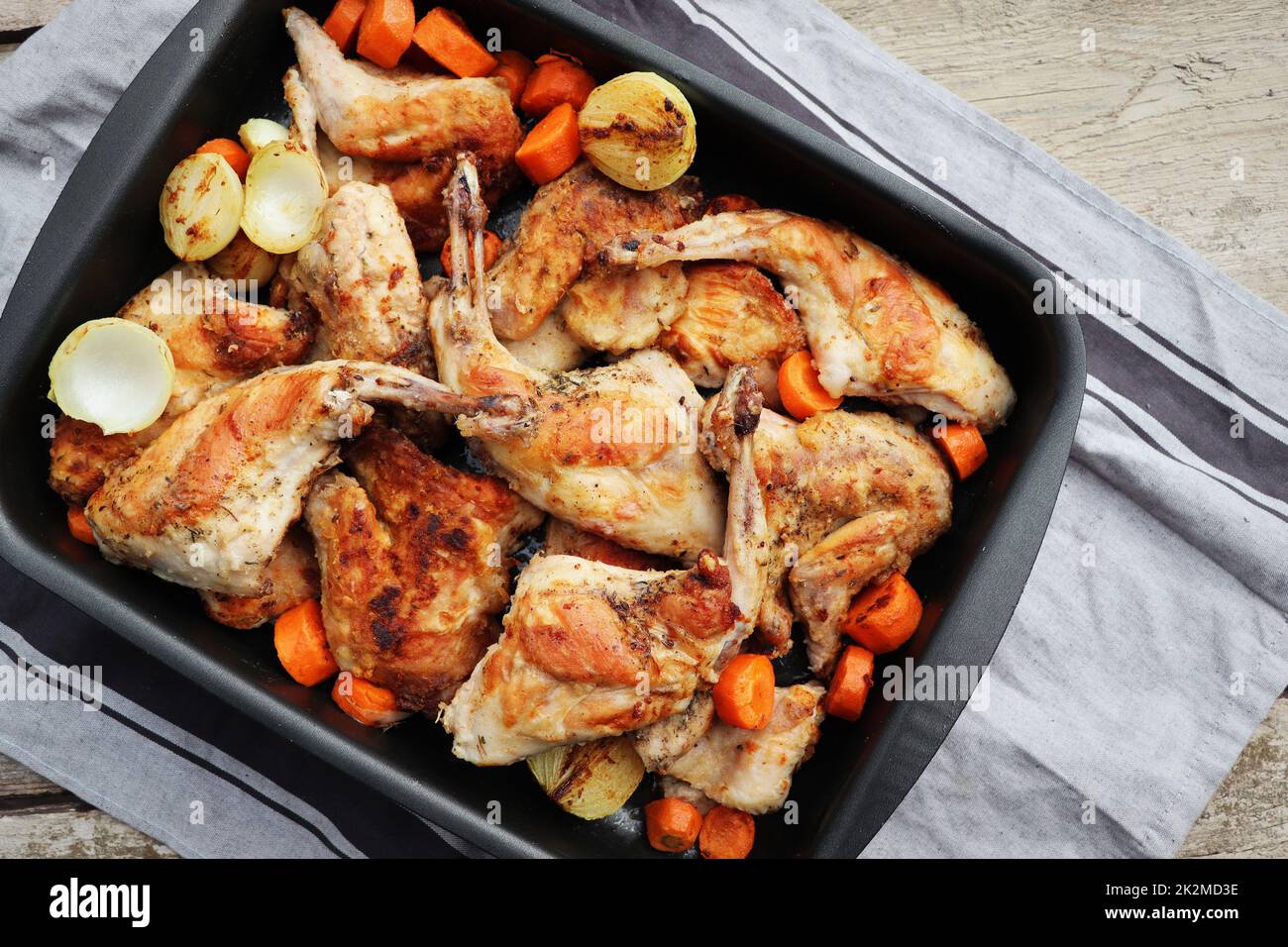 Funghi di coniglio arrosto in padella con verdure stufate su superficie rustica tavola di legno Foto Stock