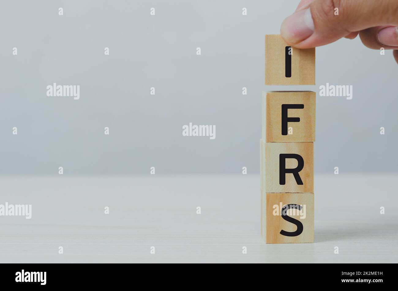 Mettere a mano cubi di legno IFRS International Financial Reporting Standards con su tavola e copy space.Business concetti finanziari. Foto Stock