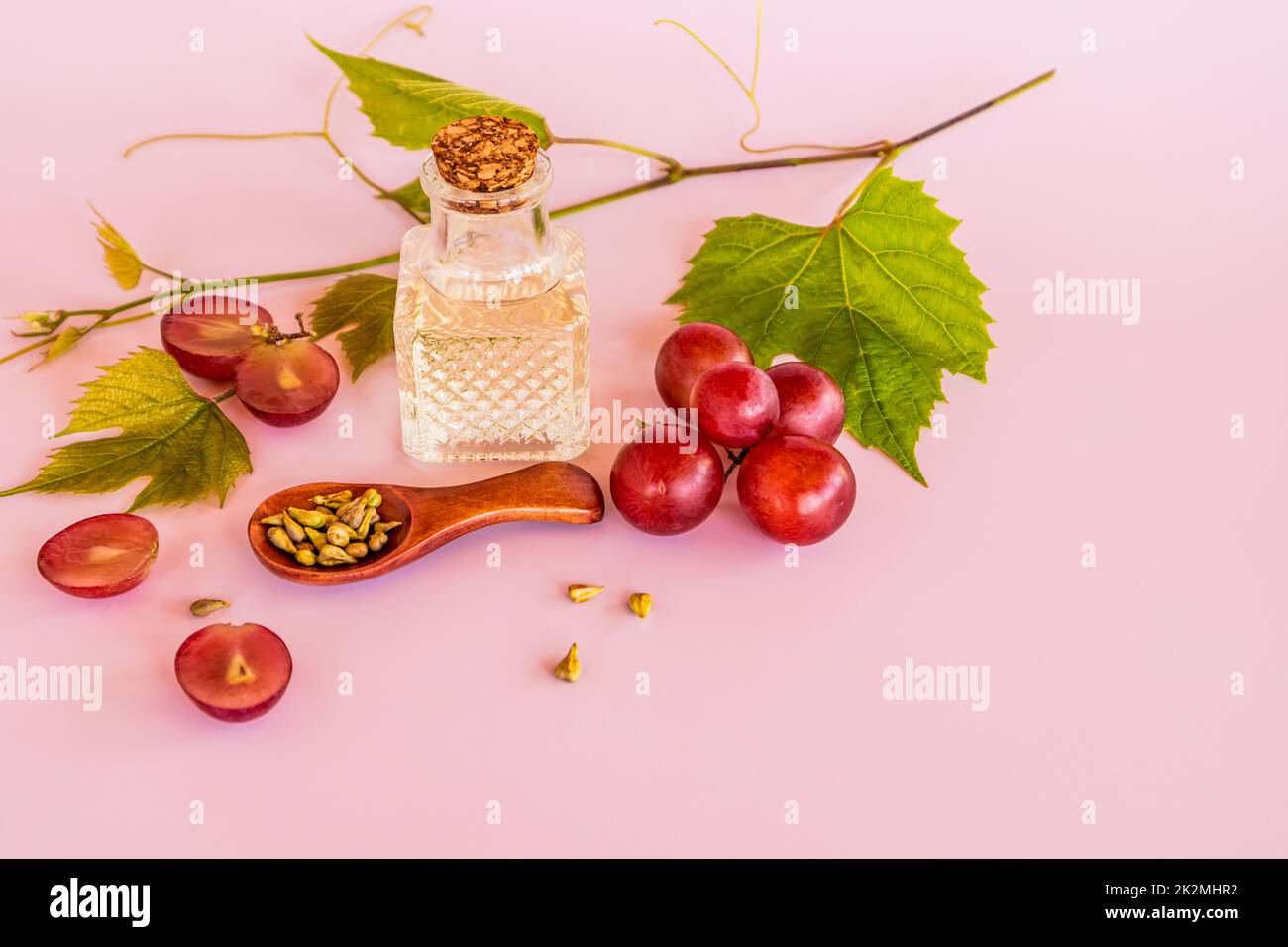 olio d'uva, un rimedio dai semi d'uva in una bottiglia trasparente di vetro con un sughero. rallenta il processo di invecchiamento, la fontana della gioventù. Foto Stock