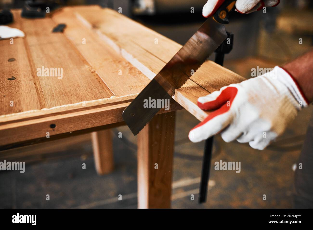 Il taglio con precisione è ciò che fa al meglio. Scatto ritagliato di un carpentiere irriconoscibile che taglia legno all'interno di un'officina. Foto Stock