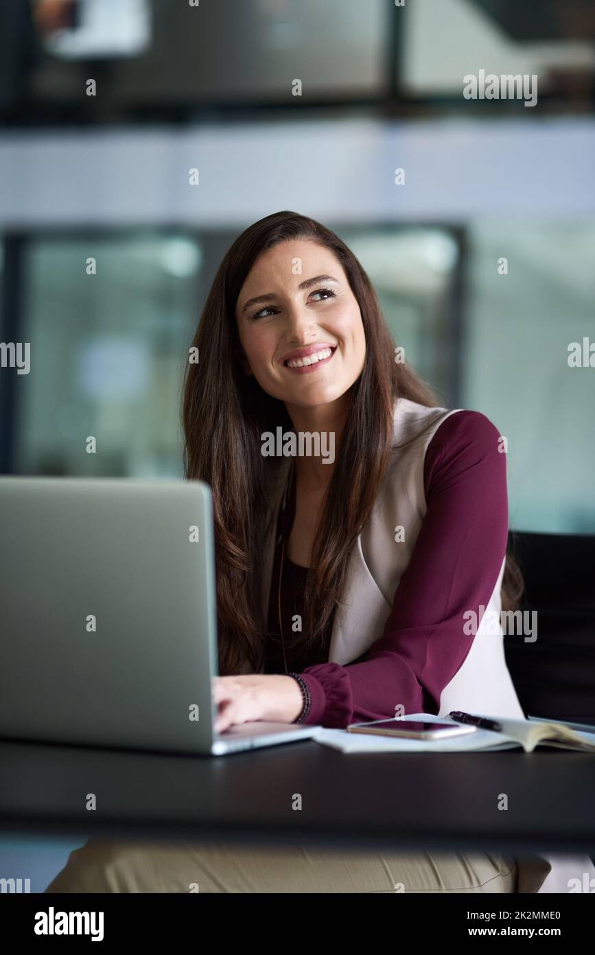Che cosa pensate è che cosa diventate. Scatto di una donna d'affari seduta alla sua scrivania con il suo laptop. Foto Stock
