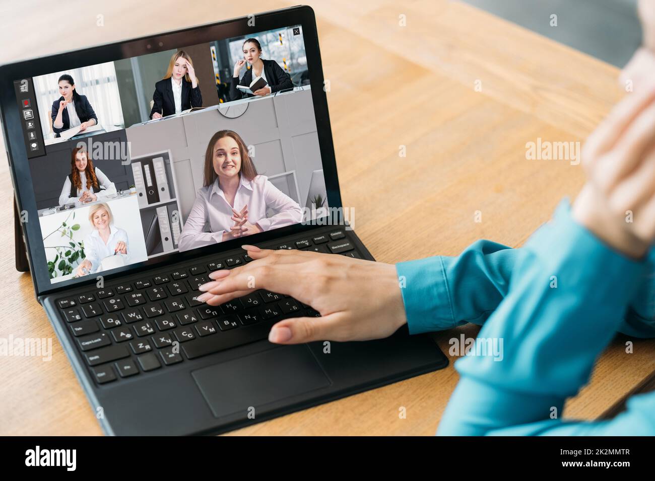 Teleconferenza aziendale. Riunione remota. Presentazione virtuale. CEO di sesso femminile che utilizza il laptop per lavorare online con il team sullo schermo in ufficio digitale. Foto Stock