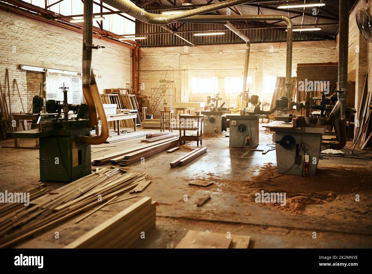 Lasciate che il lavoro inizi. Foto di vita del macchinario e mucchi di legno all'interno di un laboratorio di carpenteria. Foto Stock