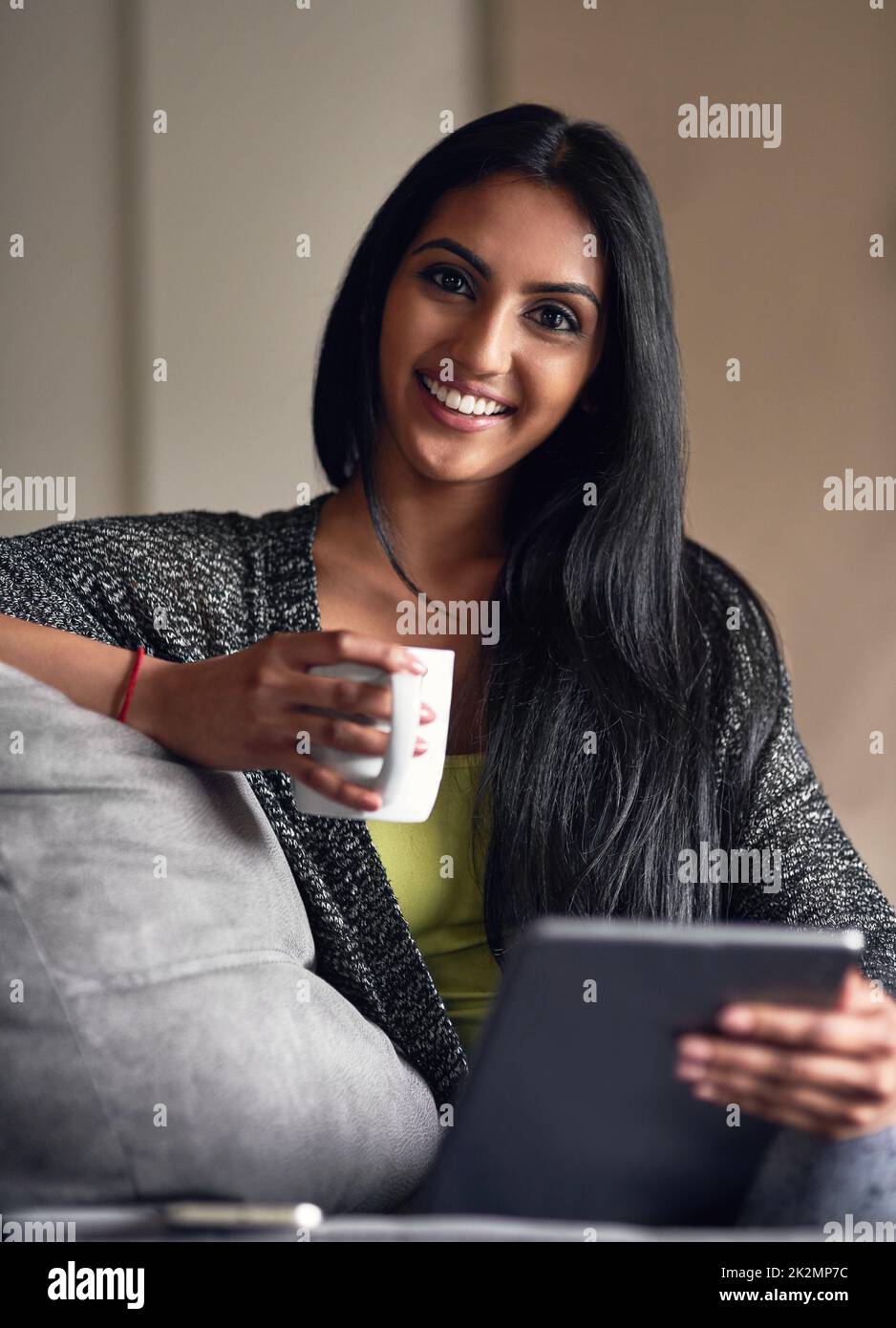 Im la definizione di un corpo domestico. Ritratto di una giovane donna attraente che naviga in rete mentre si siede sul suo divano a casa. Foto Stock