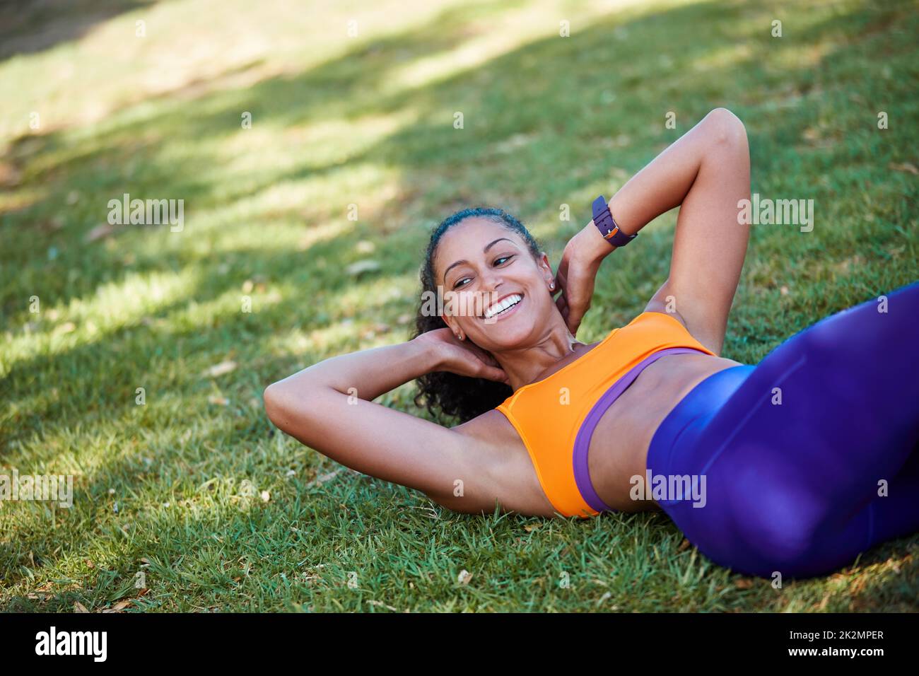 Im lavoro su un più forte me. Shot di una giovane donna sportiva che fa sit up come parte della sua routine di esercizio. Foto Stock
