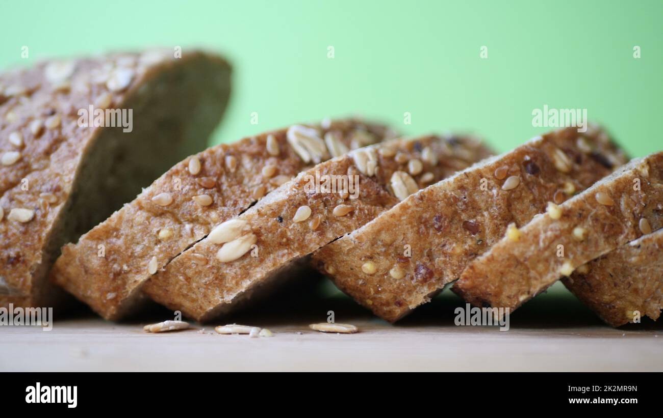 Affettare pane integrale su tavola di legno. Foto Stock