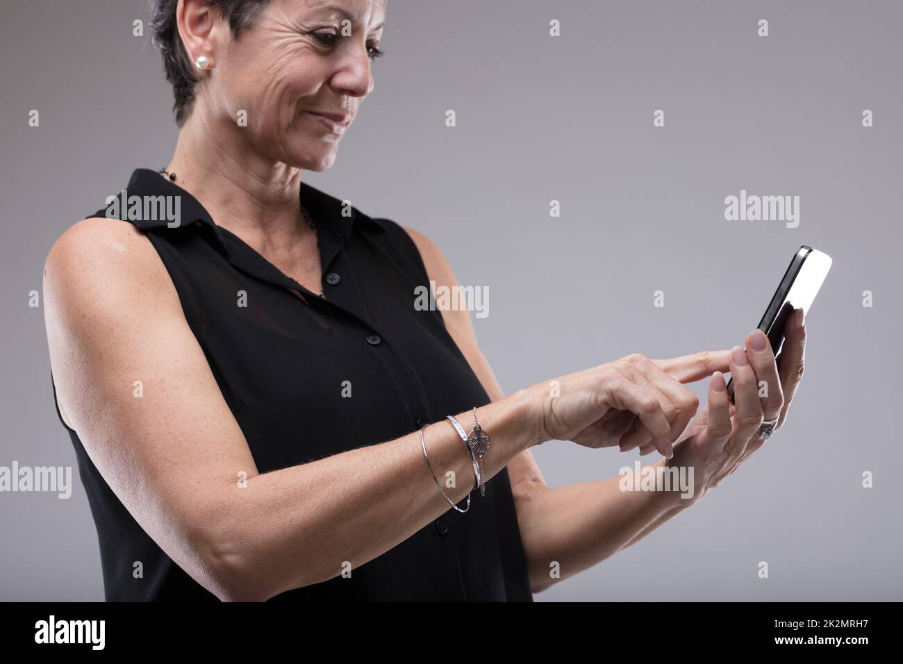 Donna sorridente che digita un messaggio di testo Foto Stock