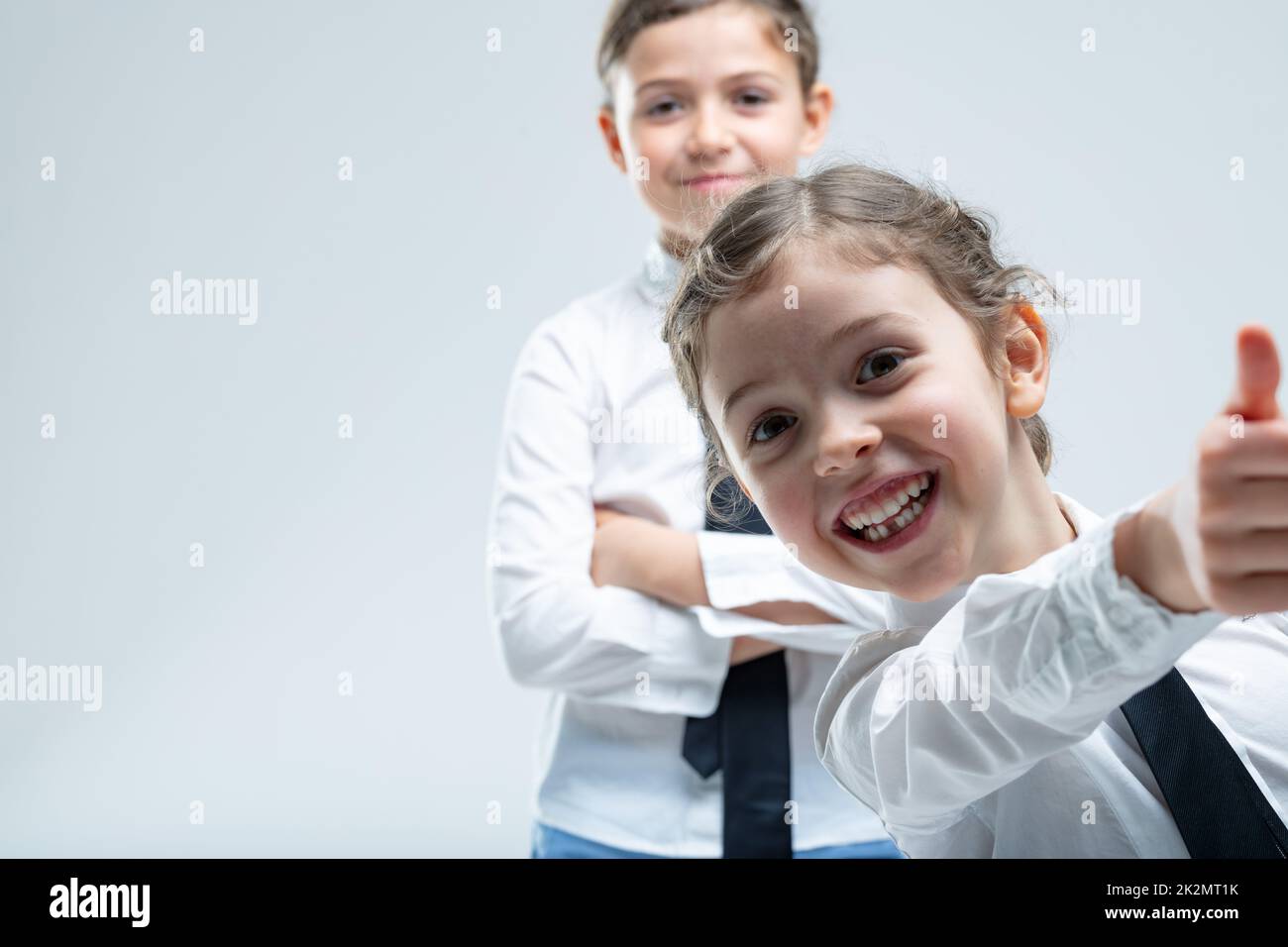 Ragazza piccola entusiasta cheeky dando un pollice in su Foto Stock