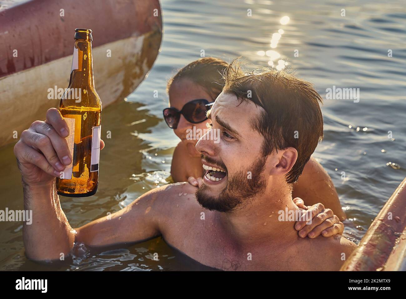 Estate spiaggia divertimento bere birra, in corso Foto Stock