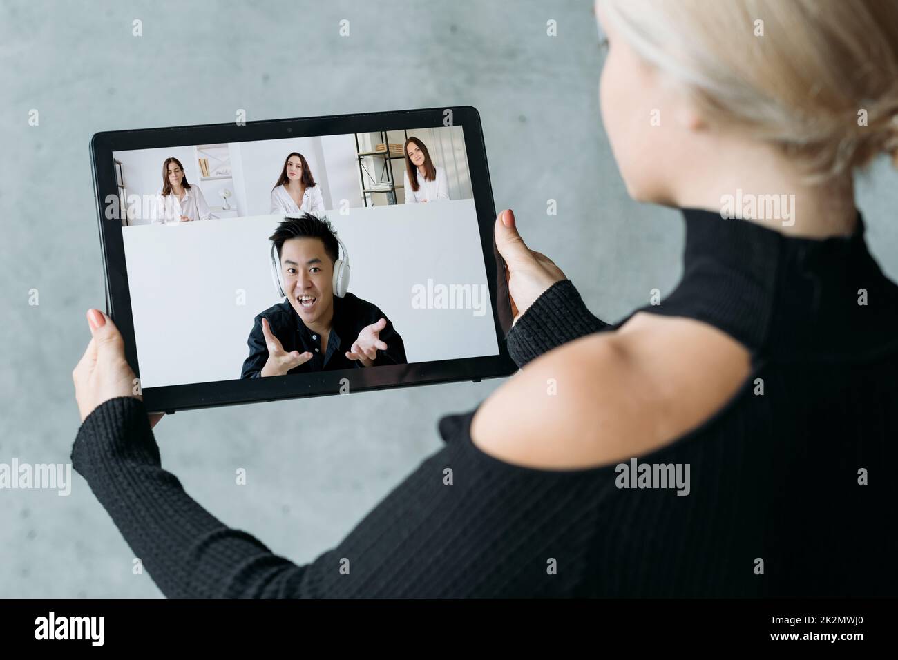 Videoconferenza. Cooperazione internazionale. Comunicazione remota. Team aziendale diversificato che lavora online per discutere il progetto sullo schermo del tablet. Foto Stock