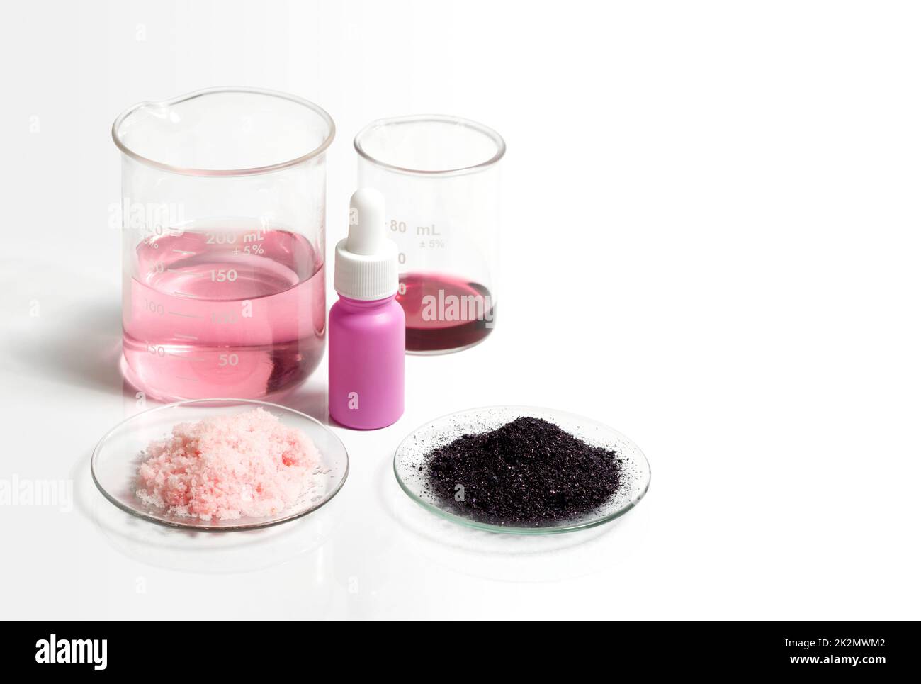 Liquido di permanganato di potassio, flacone di siero con contagocce, KMnO4 e prodotti chimici a scaglie rosa in vetro per orologi chimici. Ingrediente chimico cosmetico su tavola bianca da laboratorio. Foto Stock