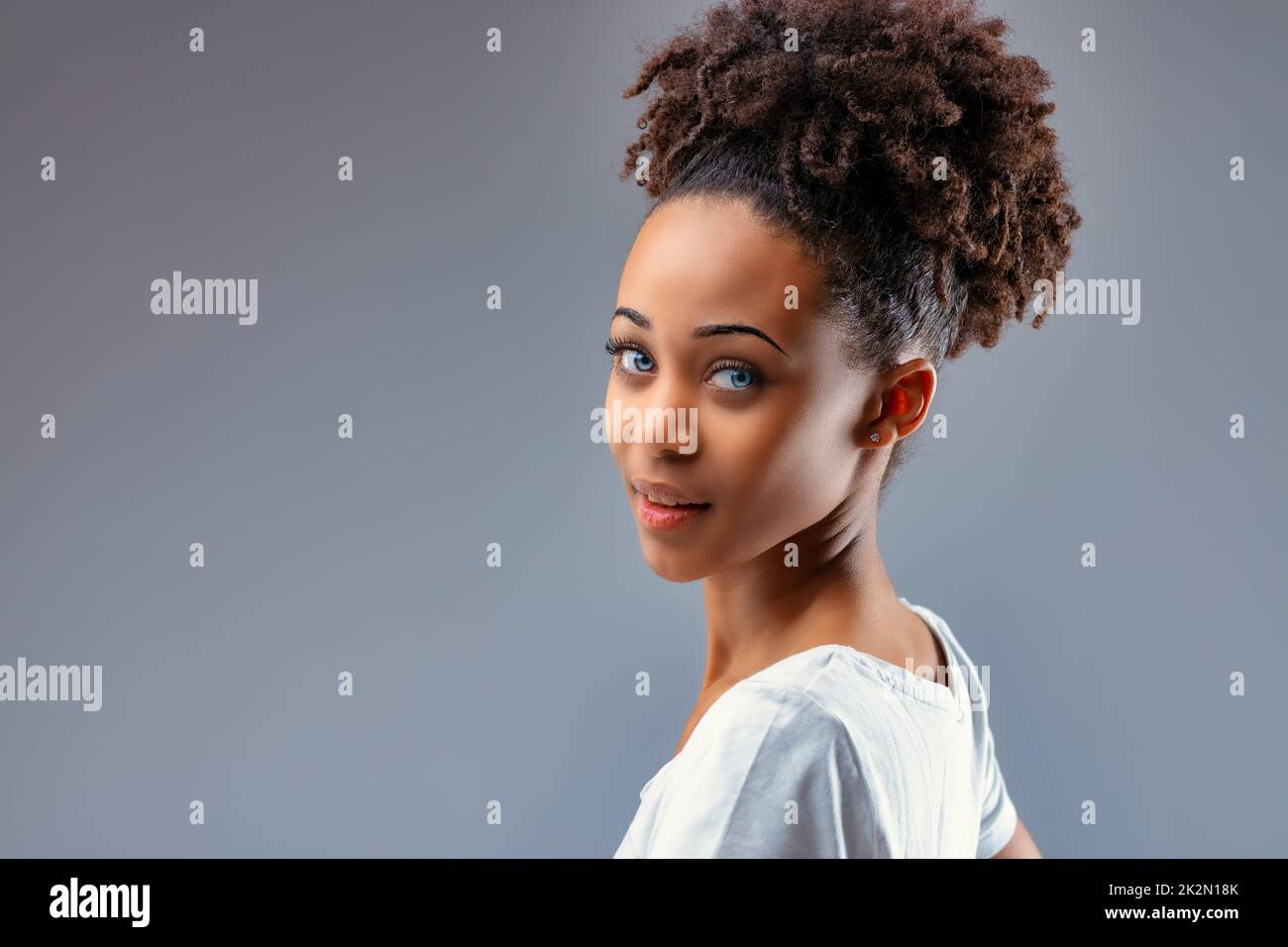 Bella giovane donna nera con occhi blu piercing Foto Stock