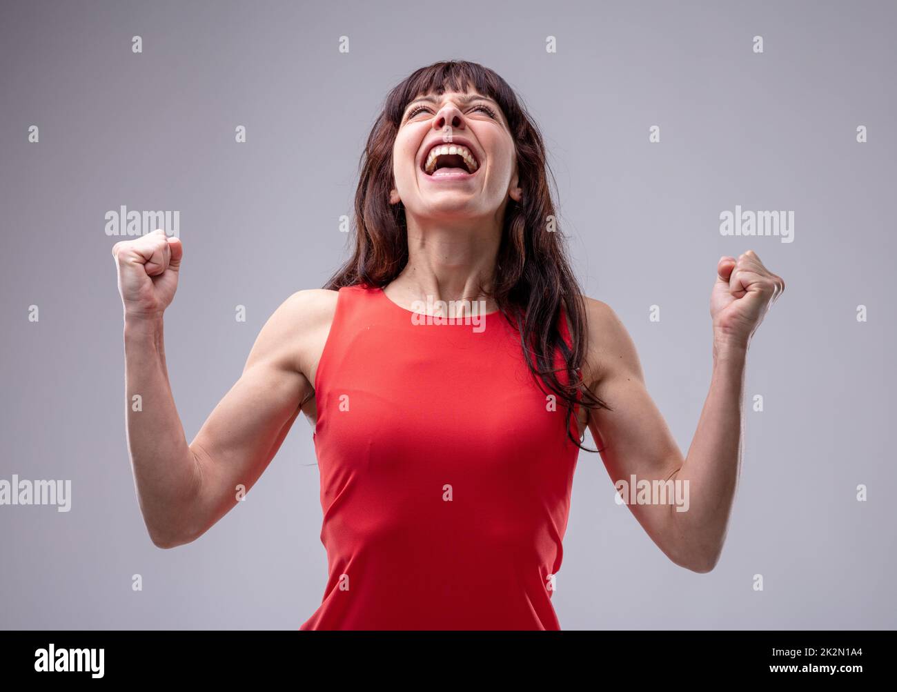 Donna eccitata che festeggia con pugni aggrappati Foto Stock