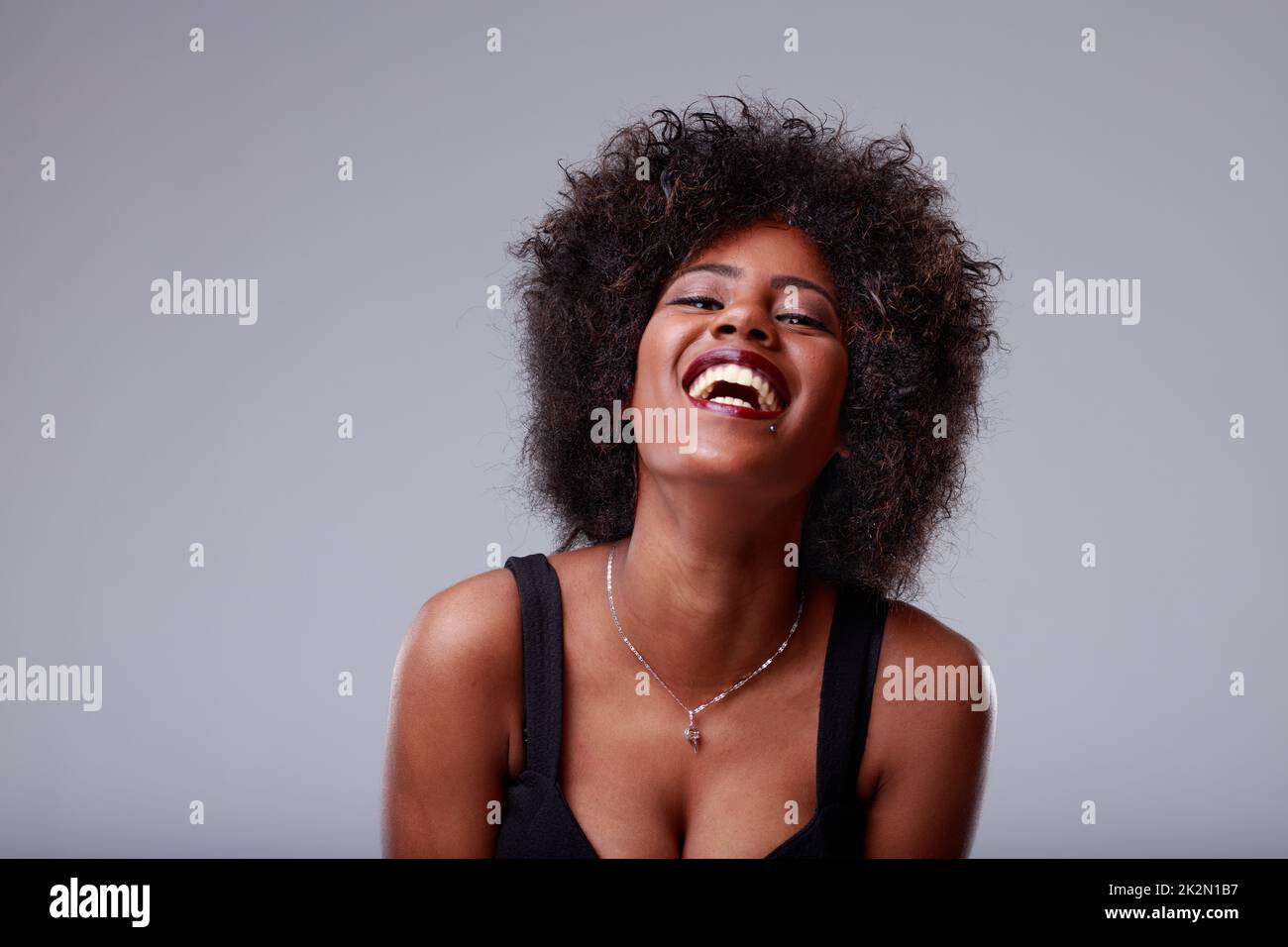 Felice divertimento amorevole giovane donna nera che ride alla macchina fotografica Foto Stock