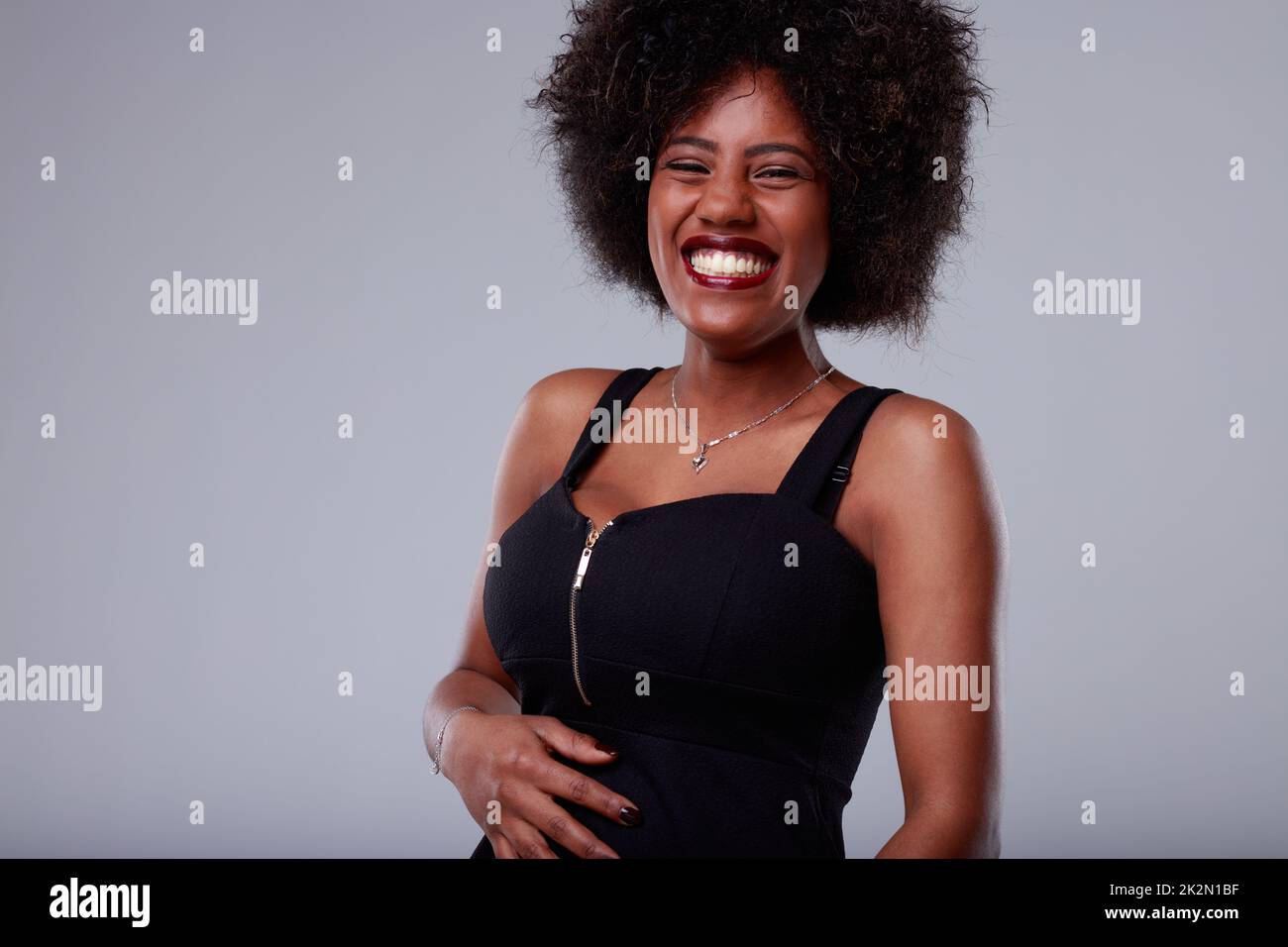 Vivace giovane donna godendo una buona risata pancia Foto Stock