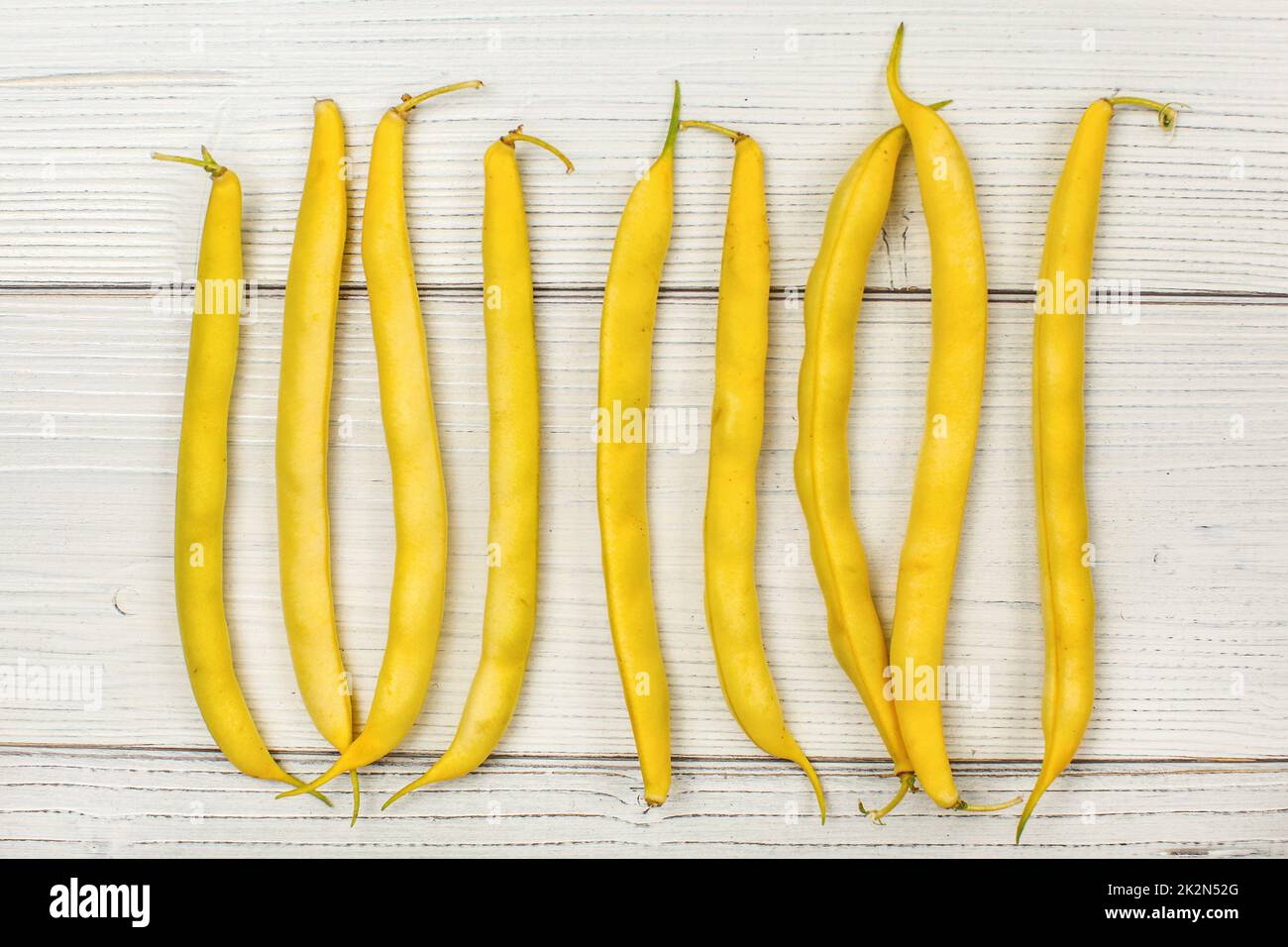 Vista del piano portapaziente - Stringa di giallo (cera) Fagioli su lavagne bianche. Foto Stock