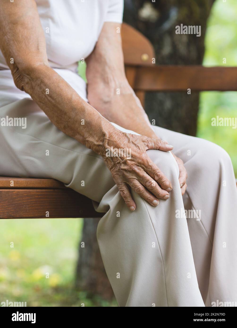 Donna anziana che tiene il ginocchio doloroso Foto Stock