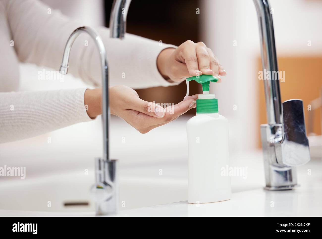 Non dimenticate di usare il sapone. Shot di una persona irriconoscibile lavarsi le mani con sapone a casa. Foto Stock