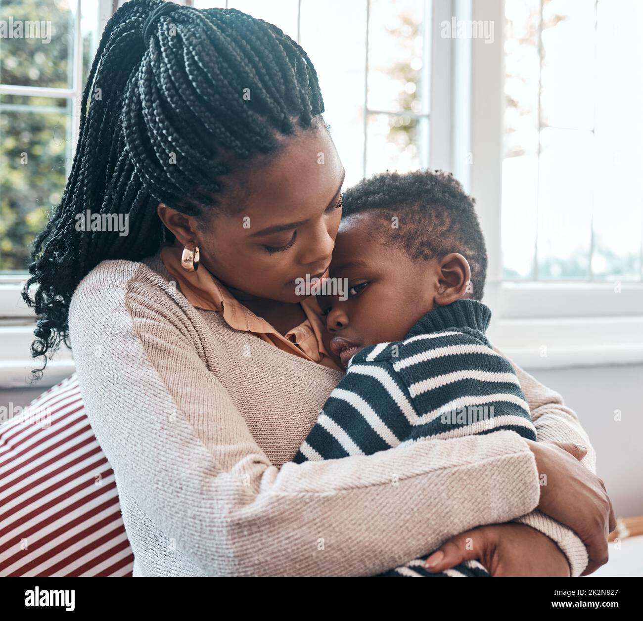 Spero che presto vi sentiate meglio. Scatto di una donna che confortava il suo figlio giovane a casa. Foto Stock