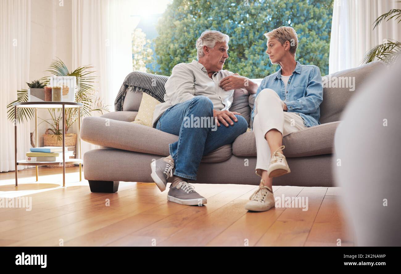 Coppia anziana, colloquio serio e comunicazione circa i problemi e le edizioni di Unione mentre sedendosi sul divano nel paese. Uomo e donna maturi che parlano e. Foto Stock