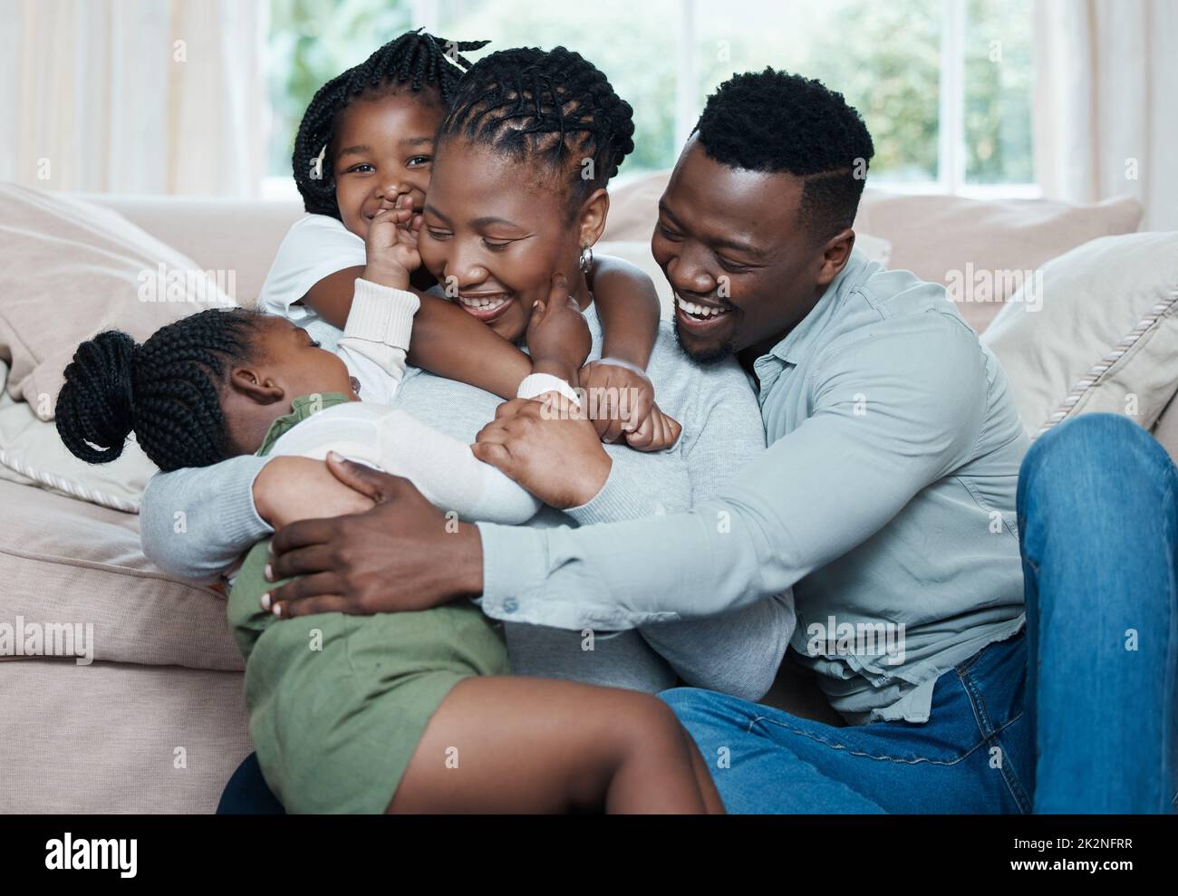 La famiglia si sente come un abbraccio caldo e confortevole. Scatto di una famiglia felice che si rilassa insieme a casa. Foto Stock